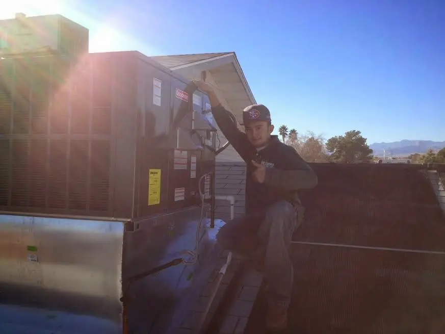 HVAC technician performing HVAC Inspection on a rooftop unit in Medford